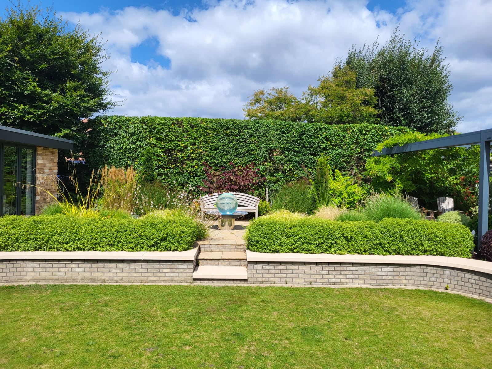 Landscaped garden with lawn, planting, seating and raised beds